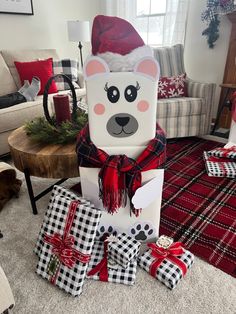 christmas presents are piled up on the floor in front of a large bear statue with a santa hat