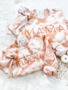 an orange and white tie dye shirt with the word mama on it next to other items