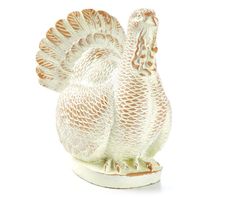 a white ceramic turkey figurine sitting on top of a table next to a white background