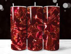 three red candles with floral designs on them