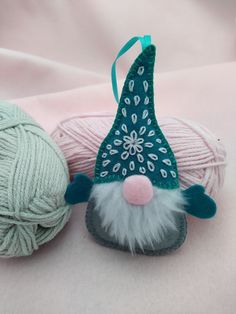 two balls of yarn are next to a gnome ornament