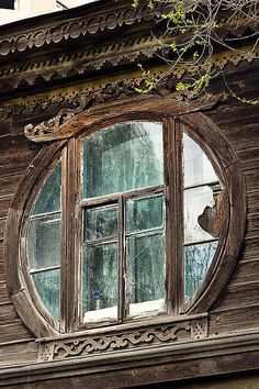 an old wooden building with a round window