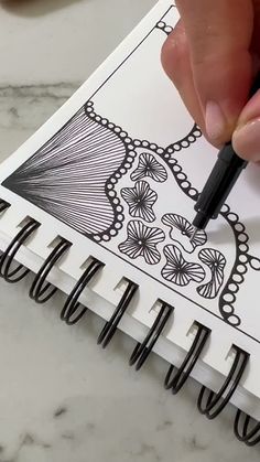 a person is drawing on paper with a pen