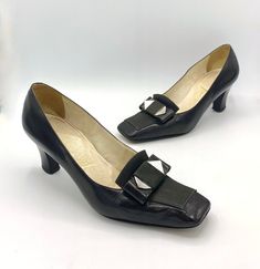 "* Mod pumps c 1960s * Black Italian leather * Tapered square toe  * Vamp features a black bow with silver triangular inset atop a matte inset on toe box * All leather upper, sole, insole, lining * Medium heel Label: Finezza - Made in Italy Very good condition. Normal creasing for age. Well cared-for shoes Marked size: 7 1/2 AA Inner Length: 10\" Outer Ball Width: 2 7/8\" Heel: 2 1/2\" To be certain of fit, measure a pair of your own shoes across the ball of the foot, and from toe to heel and co Retro Square Toe Party Heels, Retro Square Toe Heels For Party, Retro Square Toe Heels For Evening, Retro Black Heels For Formal Occasion, Black Retro Heels For Formal Occasions, Vintage Square Toe Heels For Party, Vintage Leather Heels With Bow, Vintage Square Toe Heels For Formal Occasions, Black Patent Pumps