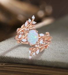 an opal and diamond ring on top of a book