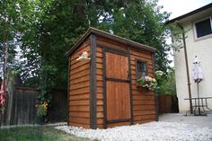 a small wooden shed sitting in the middle of a yard