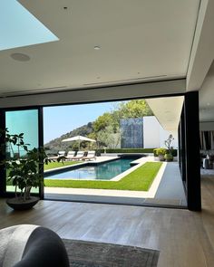 an open living room with sliding glass doors leading to a swimming pool and patio area