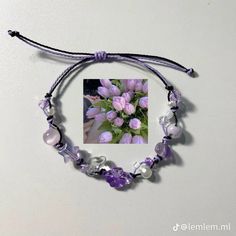 a purple bracelet with flowers and pearls on it