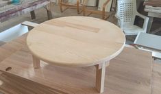 a wooden table sitting on top of a hard wood floor next to chairs and tables