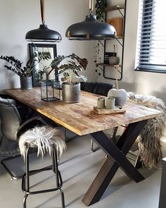 a wooden table sitting under two black lamps