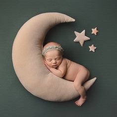 a newborn baby sleeping on the moon with stars around it's head and wearing a diaper