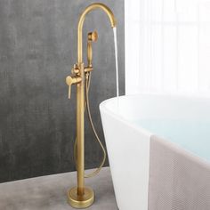 a bathtub with a gold faucet next to a white tub