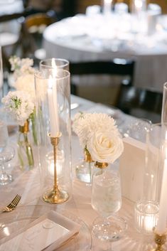 the table is set with white flowers and candles