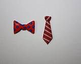 two red and blue bow ties next to each other on a white surface in front of a wall