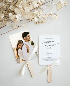 a wedding card with a photo on it next to a bouquet of flowers and ribbons