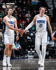 two basketball players shaking hands on the court