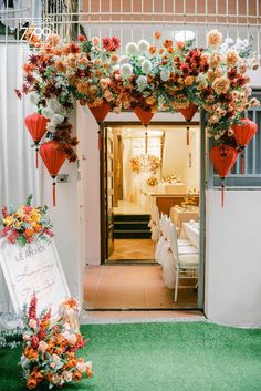 an entrance decorated with flowers and lanterns for a wedding reception at the hotel or venue