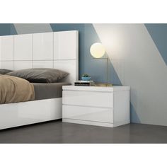 a white bed sitting next to a night stand