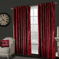 a living room with red curtains and a clock on the wall