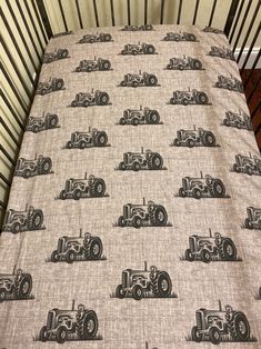 a baby bed with a tractor print on it