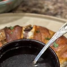 a spoon is sticking out of a bowl of black sauce