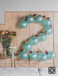 balloons are arranged in the shape of the letter e on a wall above a bed