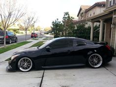 a black sports car parked in front of a house