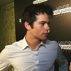 a young man standing in front of a wall