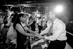 a man and woman dancing together at a party with sparklers in the air behind them