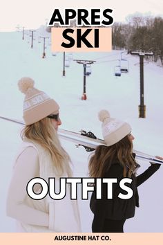 two women standing next to each other in the snow with skis on their shoulders