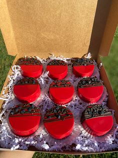 twelve red heart shaped cakes in a cardboard box