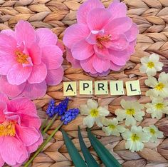 flowers and the word april spelled with scrabbles on a wicker basket