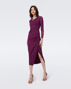 The Dorinda midi dress has a soft and stretchy feel. This piece has long sheer sleeves made from our signature mesh, an asymmetrical neckline, and a fitted silhouette. Subtle gathering features at the waist and a single slit to the mid-thigh adds a subtle edge. LENZING™ ECOVERO™ Viscose fibers are created from renewabl Wrap Dress Dvf, Plum Dress, Knit Wrap Dress, Purple Midi Dress, Midi Wrap Dress, Asymmetrical Neckline, Wrap Dress Floral, Mini Wrap Dress, Fitted Silhouette