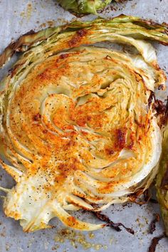 an artichoke on a baking sheet with seasoning sprinkled around it