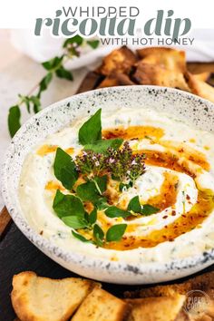 a white bowl filled with hummus and herbs