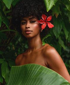 a young woman with an afro and flower in her hair is posing for the camera