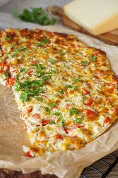 a pizza with cheese and toppings on it sitting on top of a cooling rack