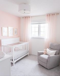 a baby's room with pink walls and white furniture, including a crib