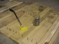 a wooden table topped with a metal container and a yellow spatula sitting on top of it