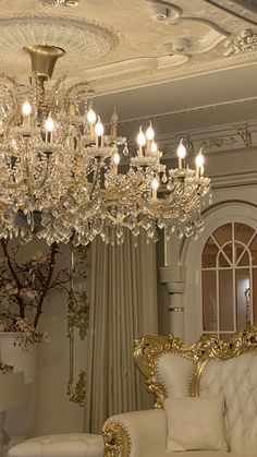 a chandelier hanging from the ceiling in a living room next to a couch