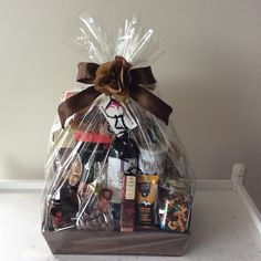 a gift basket filled with wine, snacks and other goodies for someone's special occasion