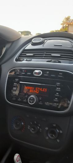 the dashboard of a car with an electronic clock on it's dash board and radio