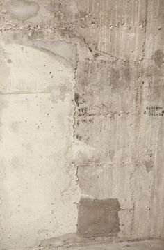 an old cement wall with graffiti on it