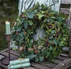 a wreath and candles are sitting on a chair