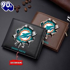 two miami dolphins leather wallets with the name and logo on them next to coffee beans