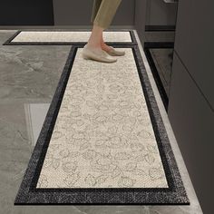 a person standing on top of a rug in the middle of a kitchen floor area