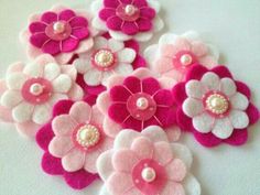 pink and white felt flowers with pearls on the center, set against a white background