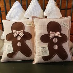 two decorative gingerbread pillows on a bed