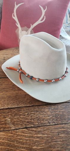 Beautiful rustic orange leather with our stainless steel beads cowgirl hat band. Lathe turned steel beads are made in the USA. Leather hat band available in 7 colors. Coolest cowboy hat band ever! #cowboyhatband #cowgirlhatband #cowboyhataccessories Silver Adjustable Hat For Rodeo, Silver Western Hat Band For Rodeo, Silver Western Hat Bands For Festival, Western Silver Hat Bands For Festivals, Custom Leather Hat Bands For Western-themed Events, Adjustable Leather Country Hat Bands, Custom Adjustable Hat Bands For Festivals, Custom Handmade Leather Hat Bands, Adjustable Leather Hat Band For Festivals