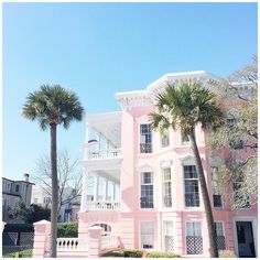 a pink house with palm trees in front of it